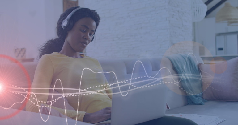 Independent artist analyzing music streaming data on a laptop with headphones.